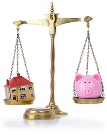 House and piggy bank balanced on scales