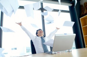 Businessman throwing arms and papers into the air